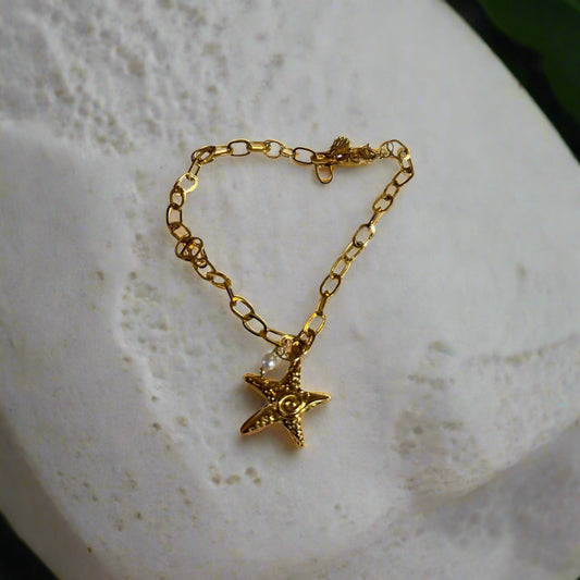 A gold-colored stainless steel waterproof bracelet with a star-shaped pendant, featuring a chain design.