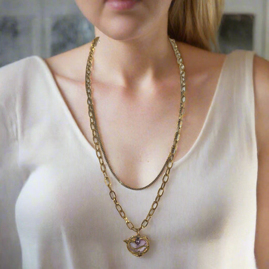 A gold-colored waterproof stainless steel necklace with a whale-shaped pendant, displayed on a mannequin bust.